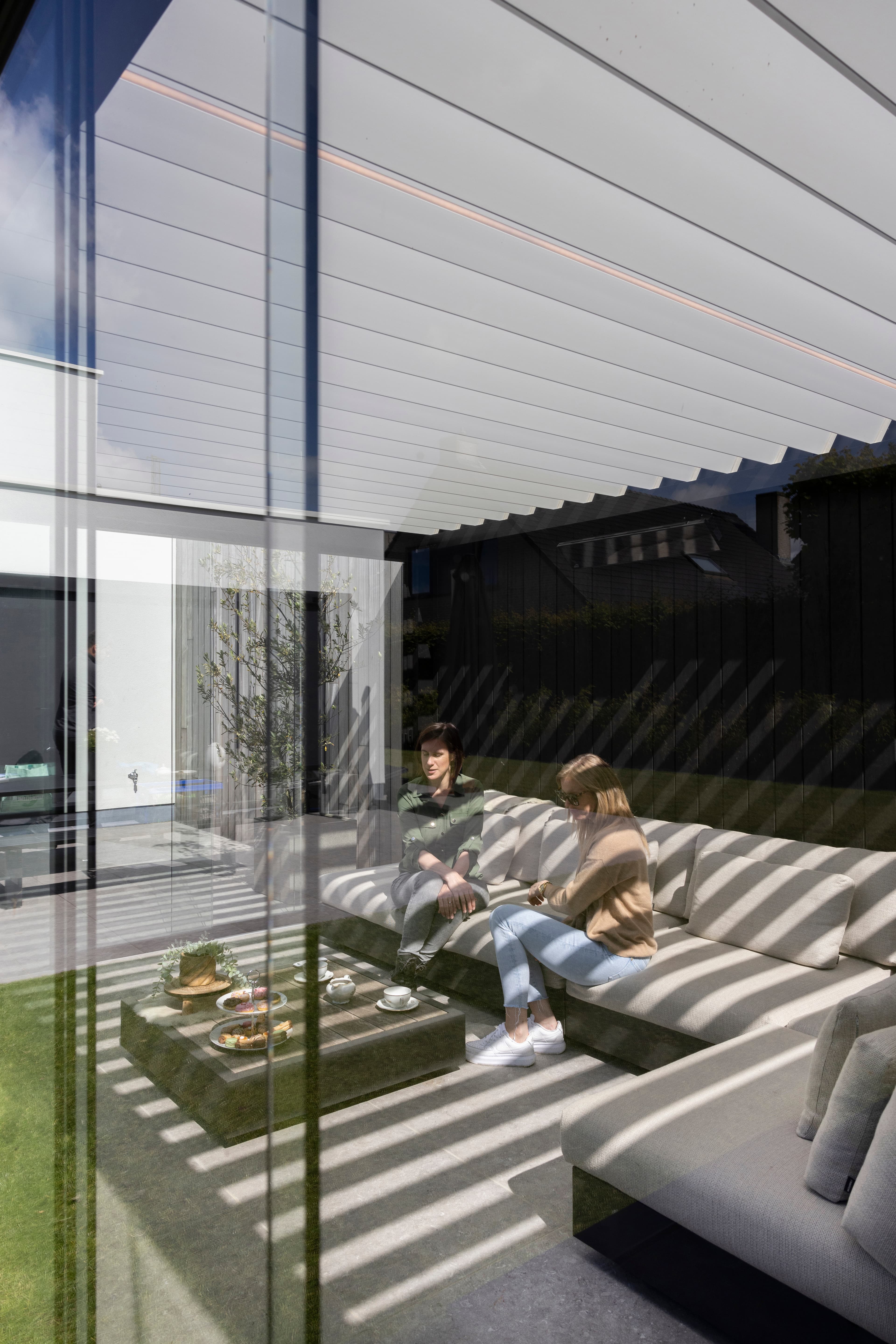 Residential glass enclosure with people lounging inside