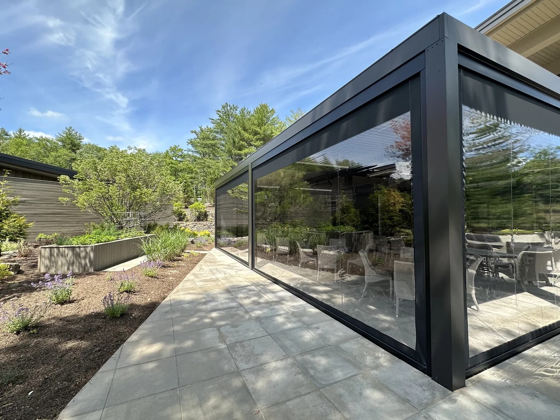 Screened patio dining area beside a landscaped garden