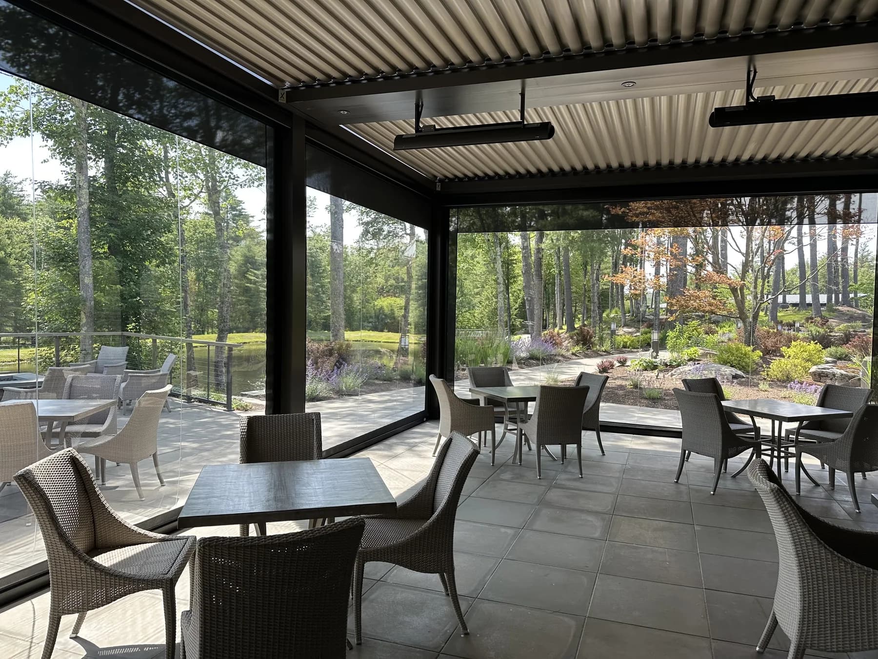 Patio dining interior beneath a louvered roof with clear enclosure panels
