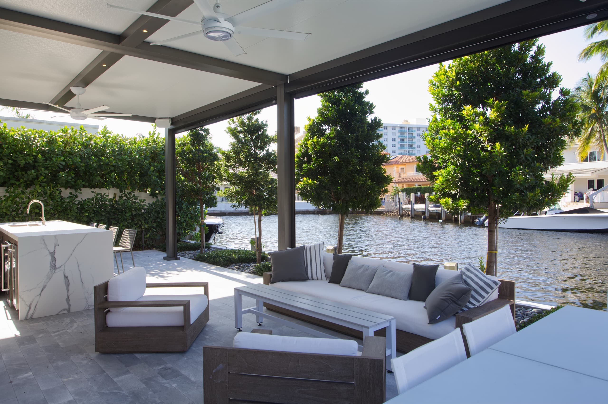 Newly installed gray and white louvered roof system replacing traditional lanai